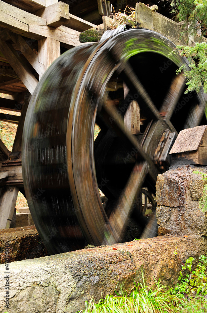 wooden wheel of an ancient water mill in motion