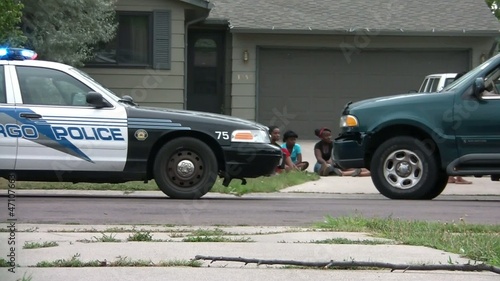 Girls Sit Next to Police Car During Investigation