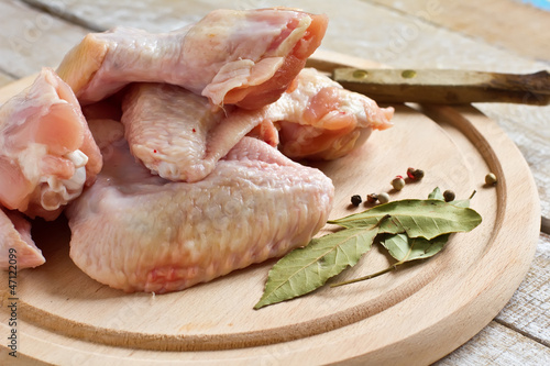 Fresh raw chicken on wooden background with pepper and bay leave