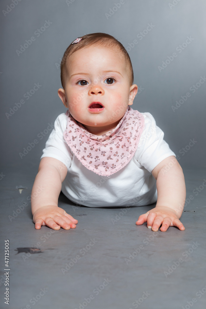 Cute baby girl against grey background. Studio shot. Cute baby girl against grey background. Studio shot.