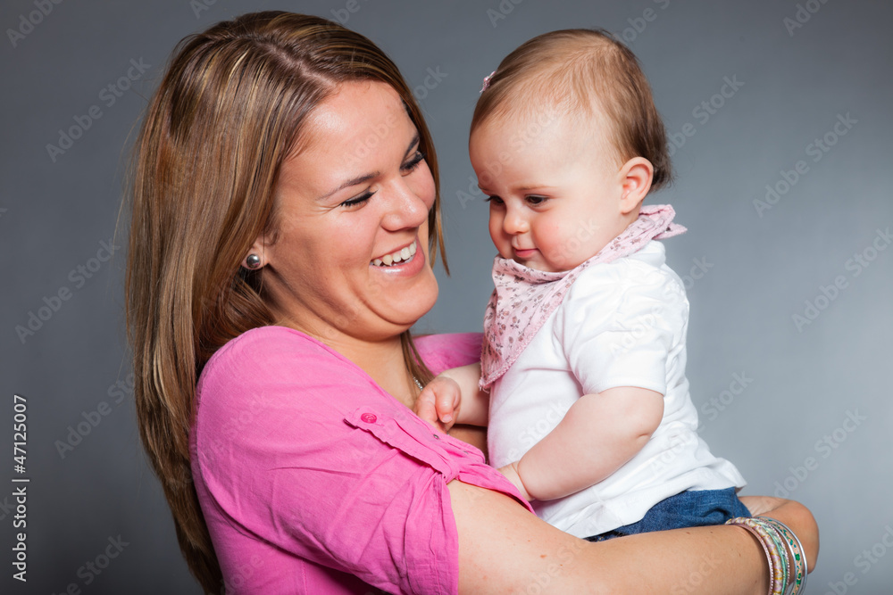 Happy young mother in love with her baby daughter. Studio shot. Happy young mother in love with her baby daughter. Studio shot.