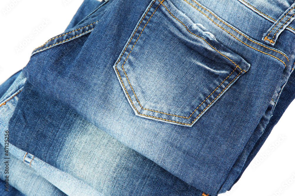 Lot of different blue jeans close-up isolated on white