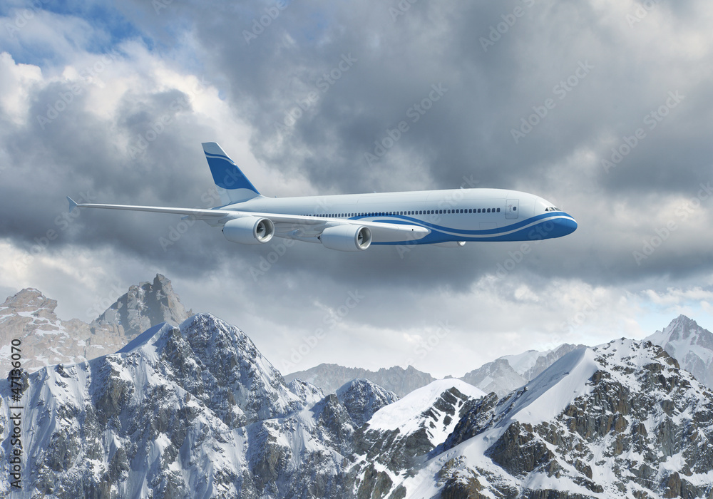 Fototapeta premium White passenger plane above the mountains