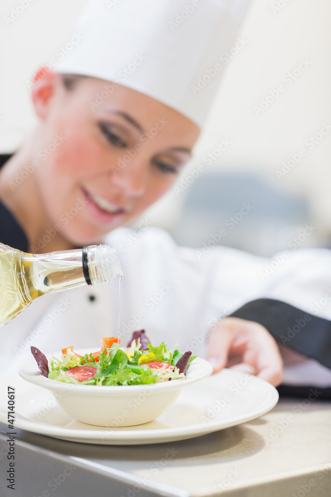 Chef pouring olive oil over salad Chef pouring olive oil over salad