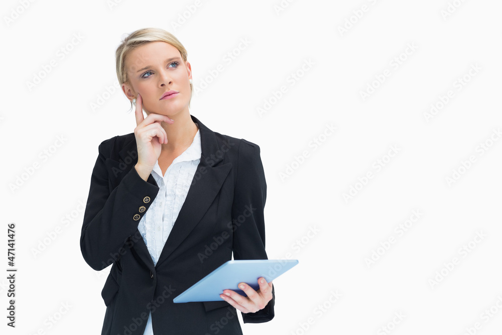 Blonde looking thoughtful while holding a tablet Blonde looking thoughtful while holding a tablet