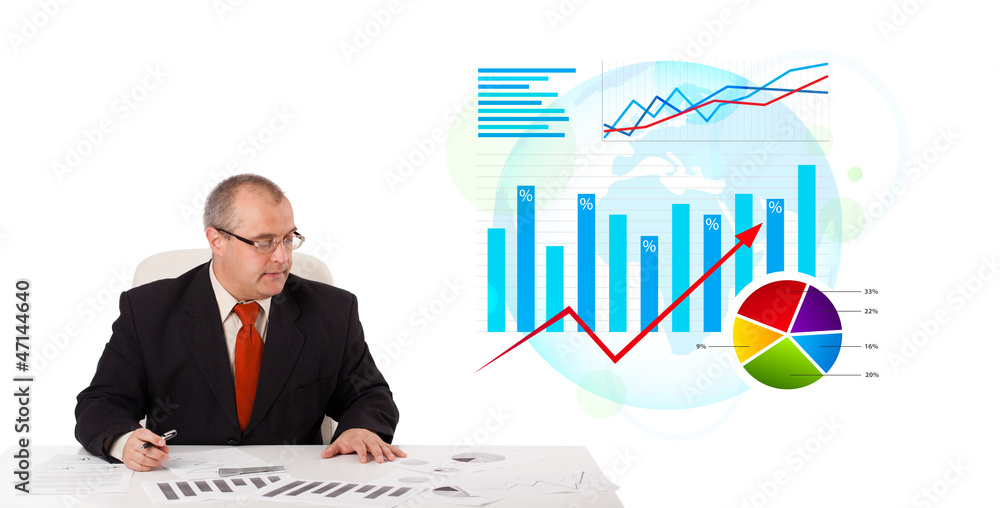 Businessman sitting at desk with statistics