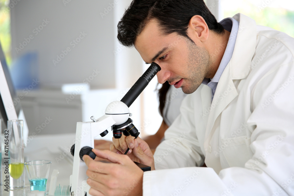 Doctor in biology working on microscope Doctor in biology working on microscope