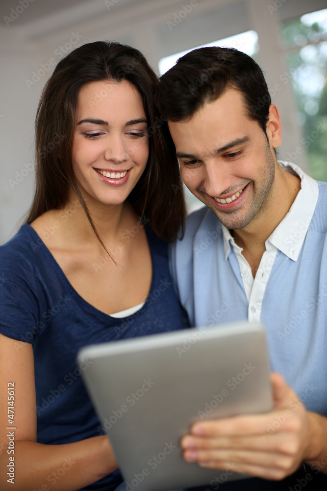Smiling couple websurfing on internet with tablet Smiling couple websurfing on internet with tablet