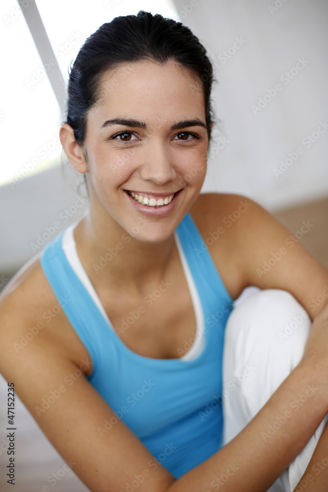 Beautiful brunette girl sitting in fitness gym