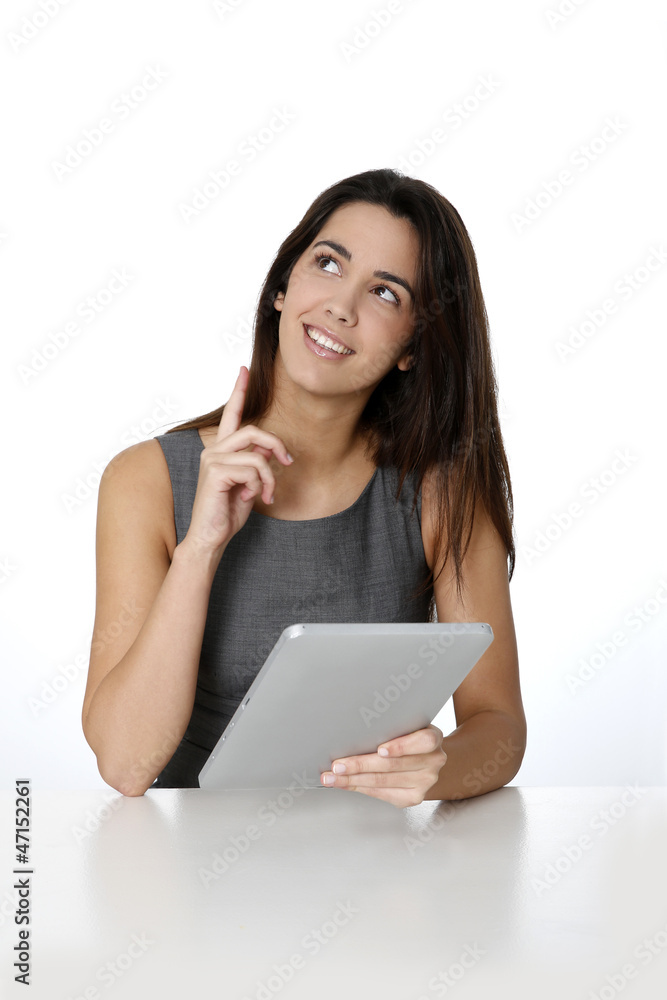 Woman using tablet and pointing at message board Woman using tablet and pointing at message board