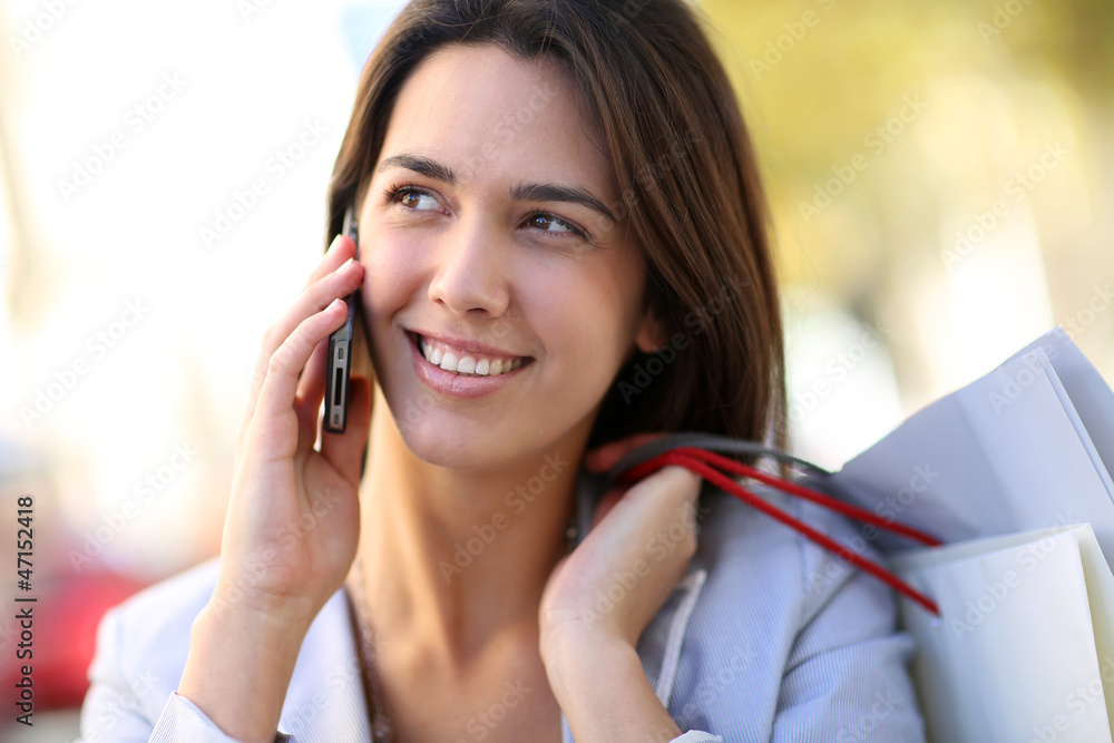 Attractive shopping girl in town talking on the phone Attractive shopping girl in town talking on the phone