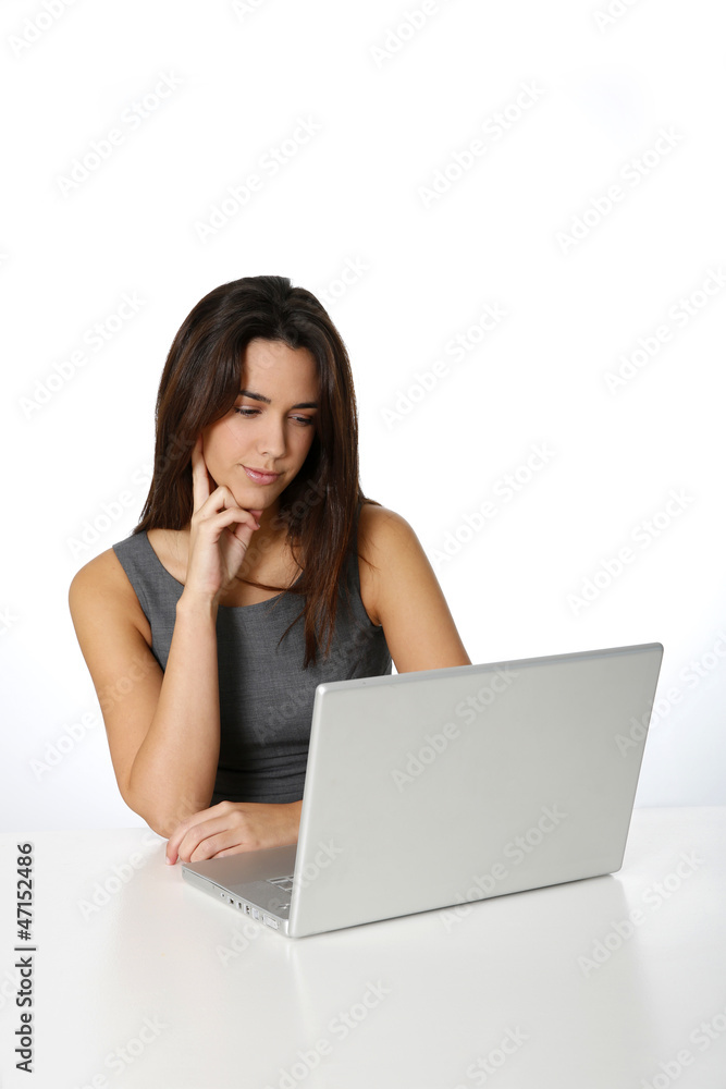 Young woman with thoughtful look in front of laptop Young woman with thoughtful look in front of laptop
