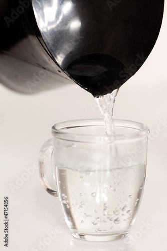 Heißes Wasser in Tasse eingießen