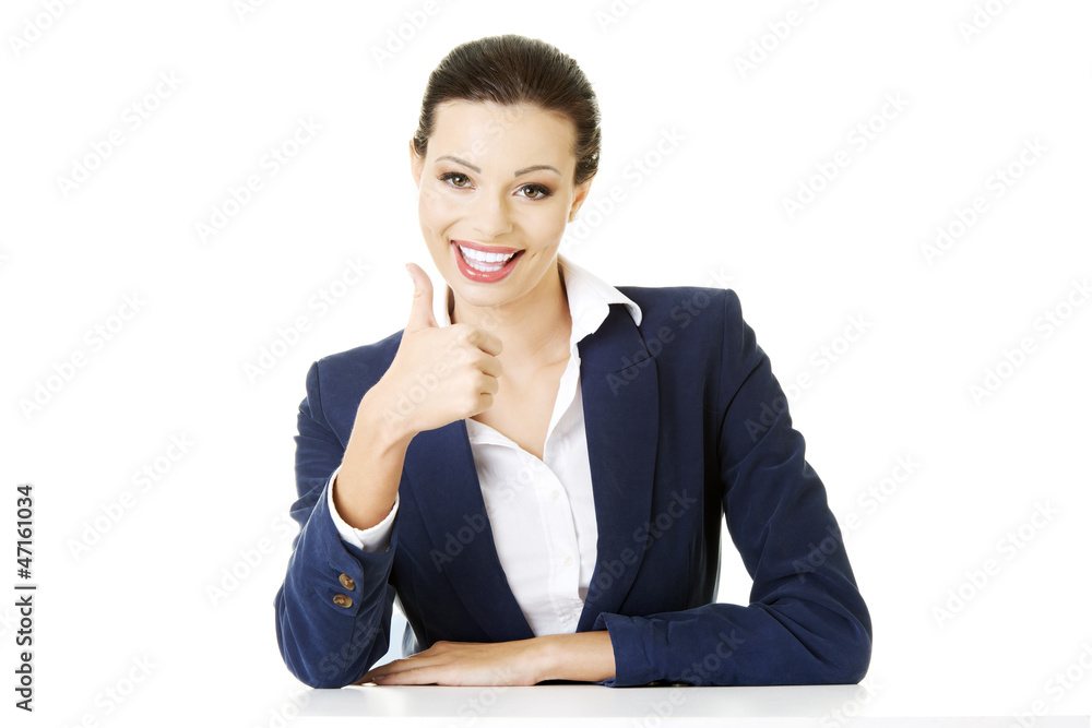 Young woman at the desk gesturing OK Young woman at the desk gesturing OK