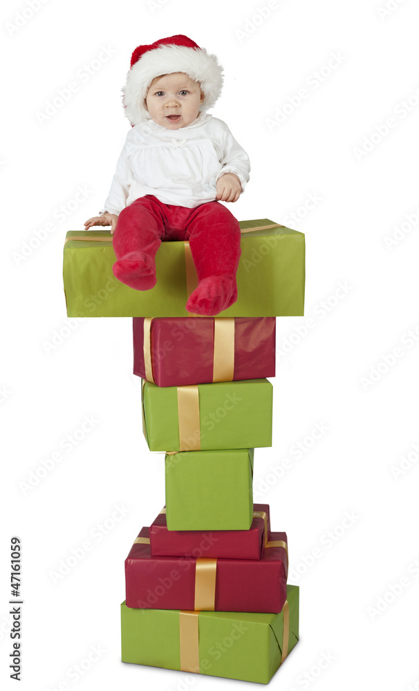 baby seated on a stack of christmas presents; on white baby seated on a stack of christmas presents; on white