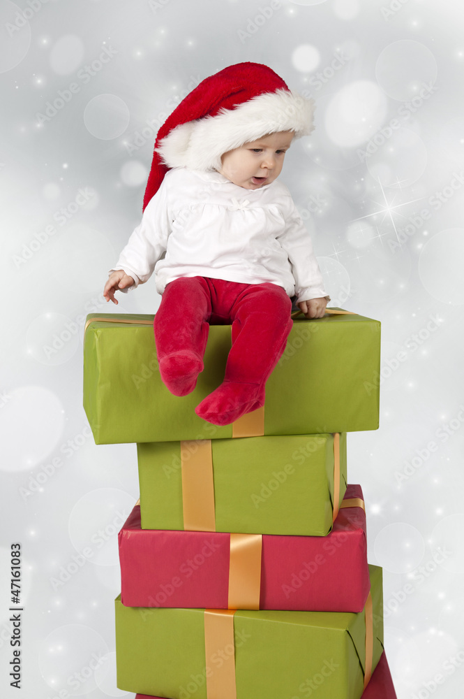 baby seated on a stack of christmas presents baby seated on a stack of christmas presents
