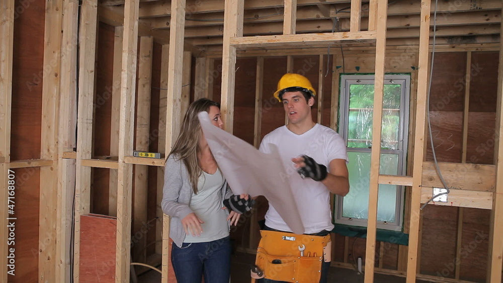 Woman and builder discussing the blueprints Woman and builder discussing the blueprints