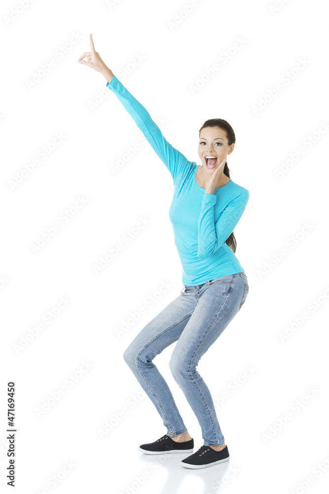 Excited young woman pointing on copy space