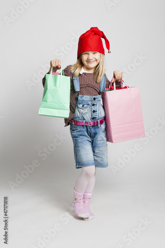 Smiling girl carrying Christmas shopping bags