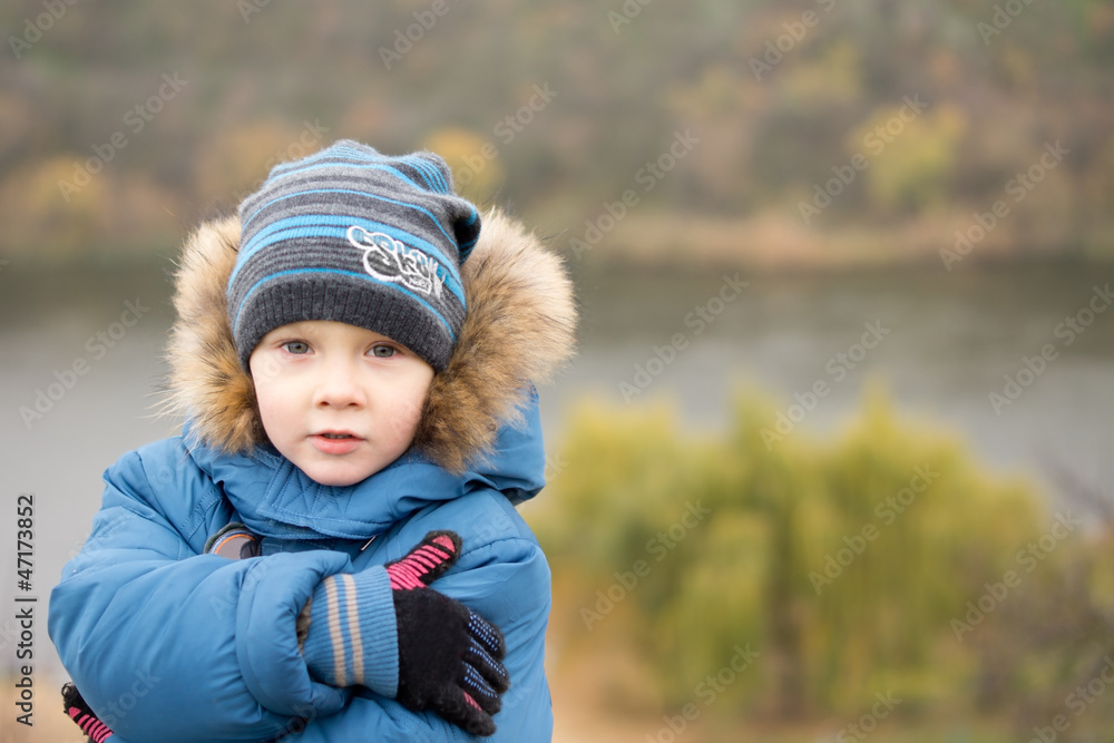 Cute cold little boy hugging himself