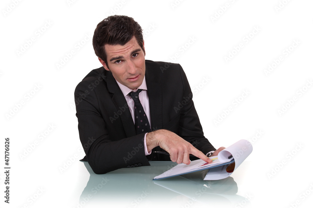 Businessman pointing to his clipboard Businessman pointing to his clipboard
