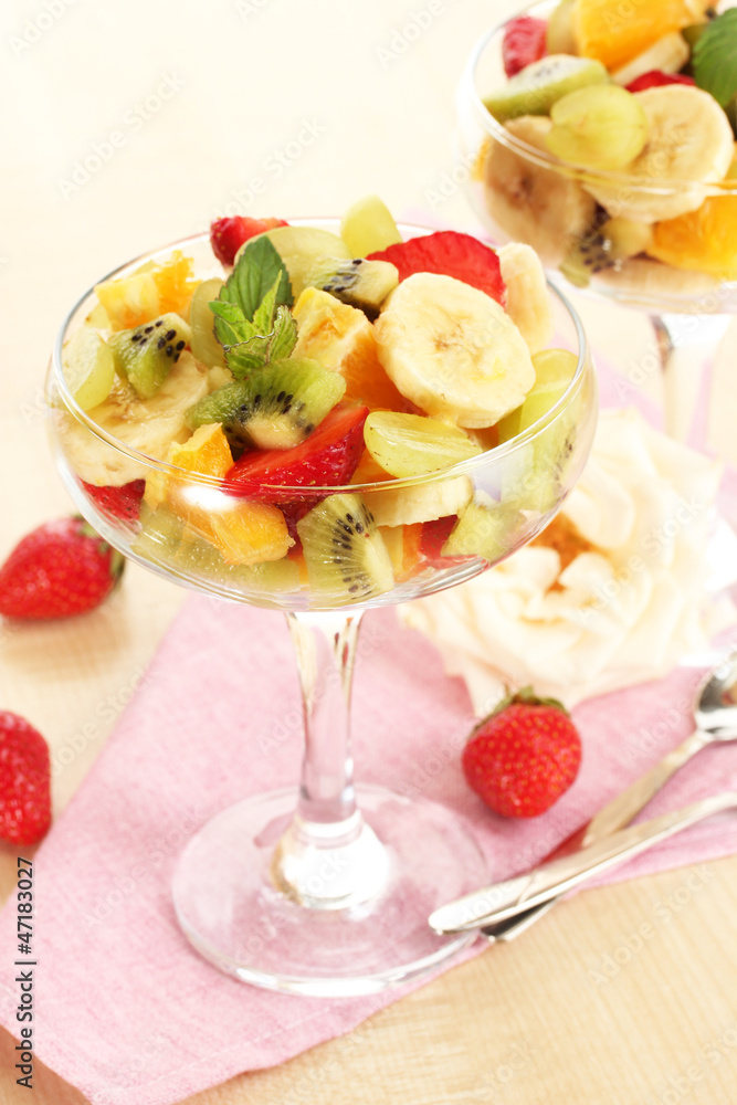 Fresh fruits salad and strawberries on wooden table Fresh fruits salad and strawberries on wooden table