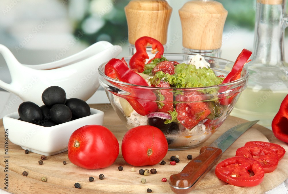 Fresh greek salad in glass bowl surrounded by ingredients for Fresh greek salad in glass bowl surrounded by ingredients for