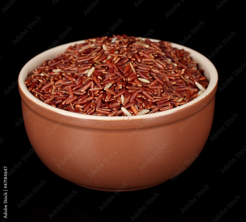 Red rice in brown bowl isolated on black Red rice in brown bowl isolated on black