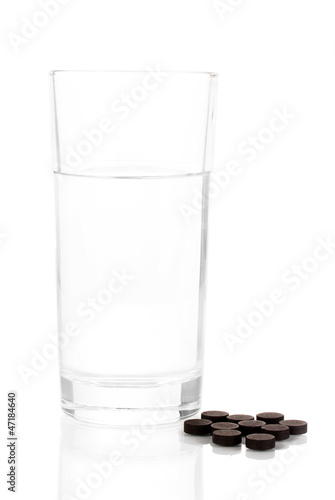 glass of water and activated carbon isolated on white