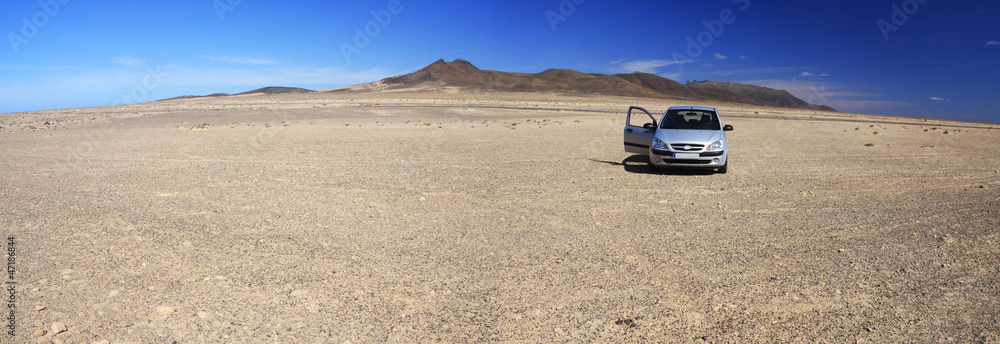 Rocky desert and car - obrazy, fototapety, plakaty 