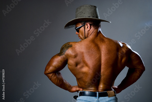 Muscular man in a cowboy hat and sunglasses