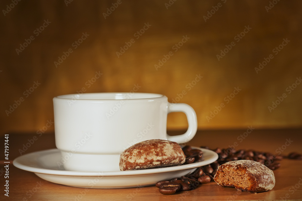 White cup of coffee with coffee beans and cakes White cup of coffee with coffee beans and cakes