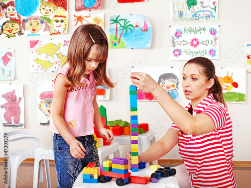 Child playing construction set with mother. photo