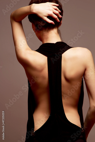 A beautiful woman, back view, isolated on brown background