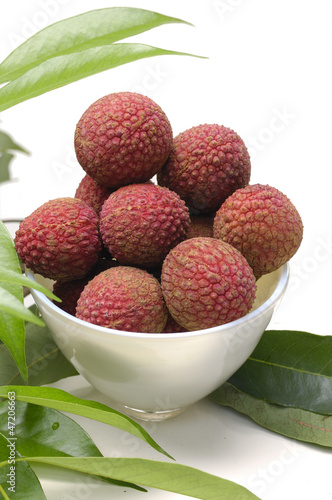 Bowl of peeled lychee with green leaf