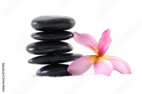 Stacked of stones and red flower on white background