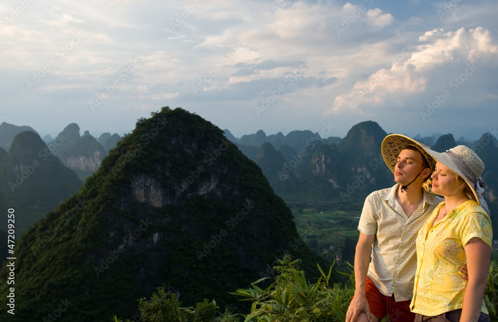Naklejka premium lovely couple relaxing on top of the mountain Guilin, Yangshuo