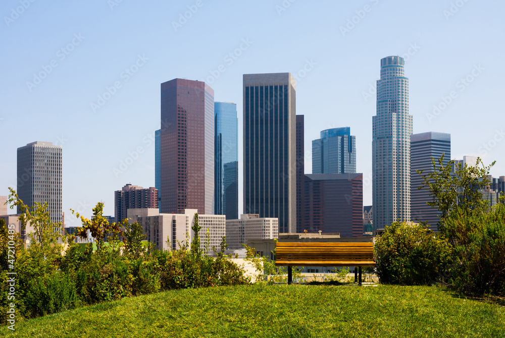 Naklejka premium Skyscrapers in Los Angeles with a bench in a foreground