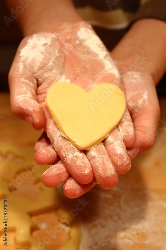 Plätzchen, Kekse backen mit Herz in Kinder-Hand