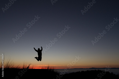 silhouetted of man jumping in sunset