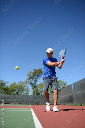 Tennis Payer retuning a ball © Carlos Santa Maria