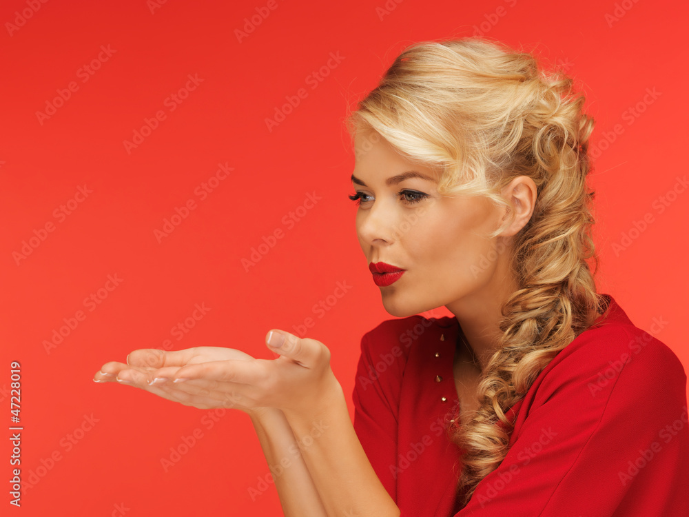 woman blowing something on the palms of her hands