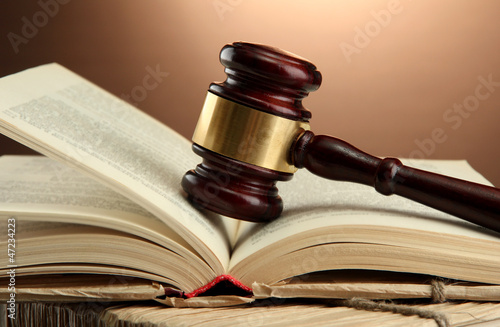 wooden gavel on books, on brown background