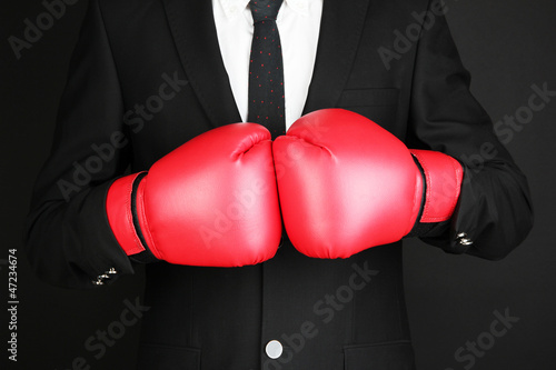 businessman in boxing gloves isolated on black © Africa Studio