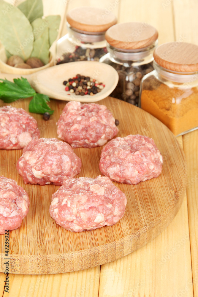 Raw meatballs with spices on wooden table Raw meatballs with spices on wooden table