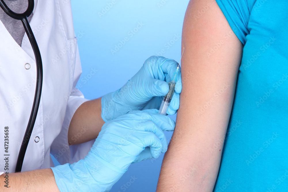 doctor holding syringe with vaccine into patient's shoulder doctor holding syringe with vaccine into patient's shoulder