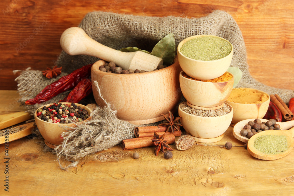 mortar, bowls and spoons with spices, on wooden background mortar, bowls and spoons with spices, on wooden background