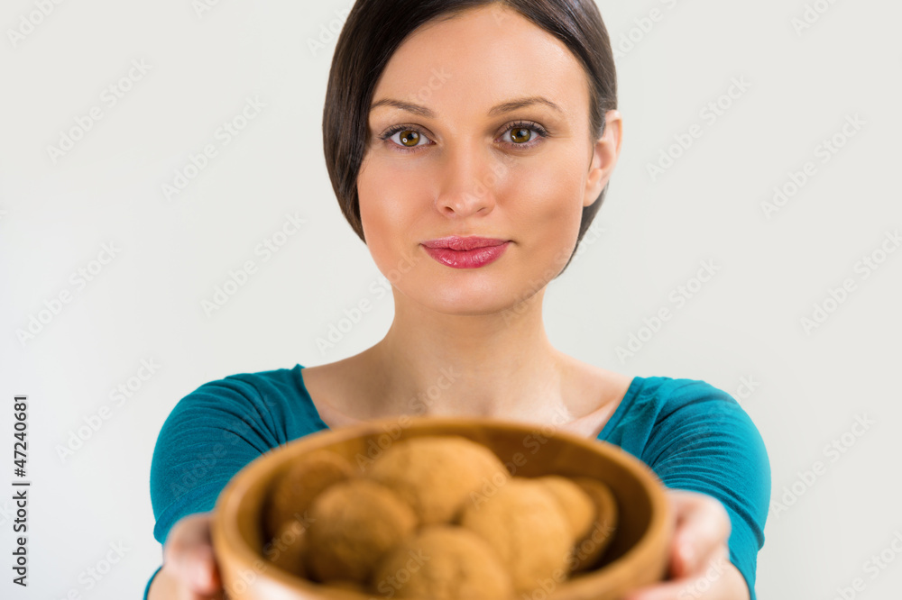 Beautiful woman holding hot fresh smelling oat cookies and smili Beautiful woman holding hot fresh smelling oat cookies and smili