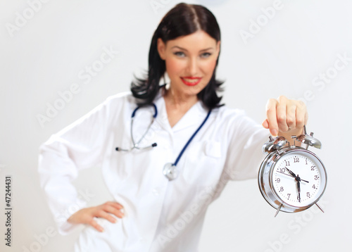Young female doctor with clocks