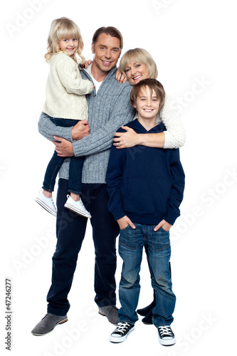 Affectionate family of four posing in winter outfits